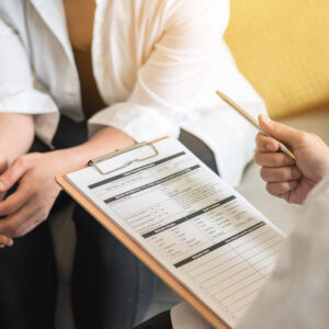 Doctor (gynecologist or psychiatrist) consulting and examining woman patient's health in medical clinic or hospital health service center