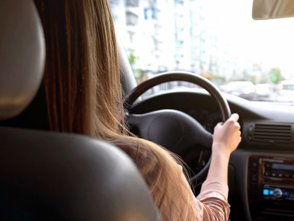 Business woman driving automobile in city center, transportation in rush hour