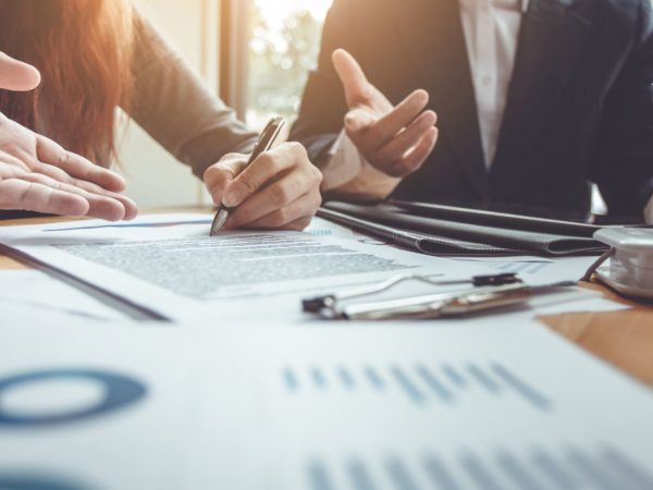 Business people review paper work at table