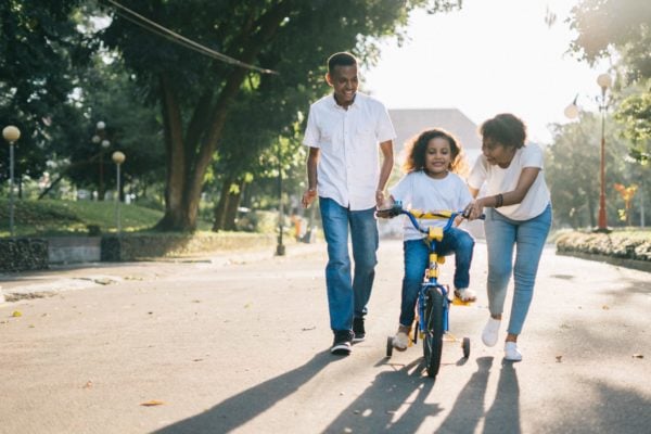 family parents and child riding bike