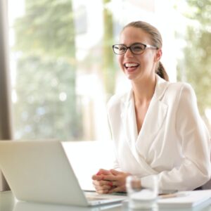 young professional woman smiling in front of laptop